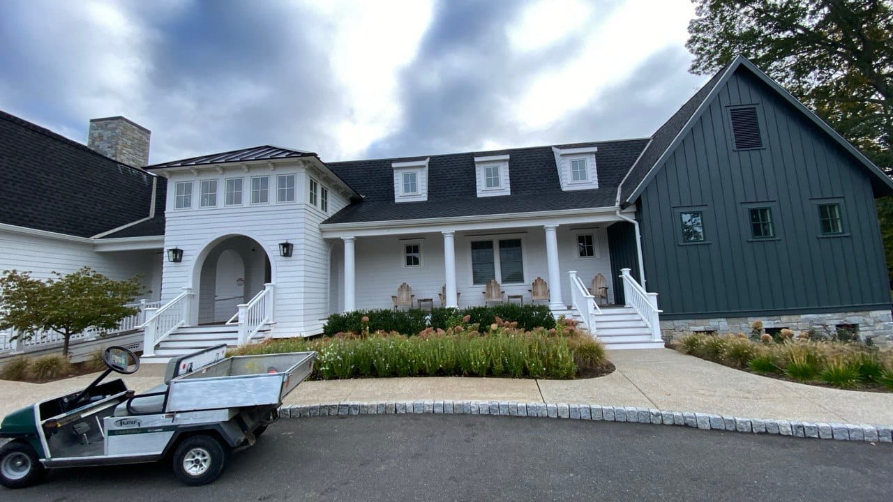 Gutter repair on luxury white estate with metal roof